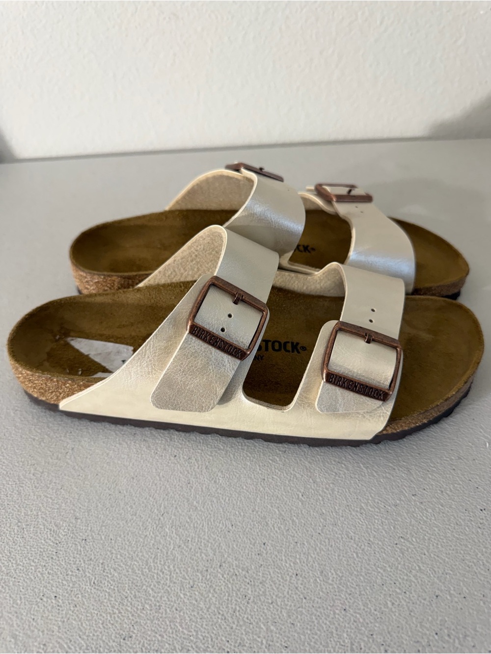 Birkenstock Arizona sandals featuring a shimmery Graceful Pearl White upper